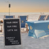 Beach bonfire setup with table and chairs on the sand